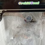 箱の窓から見えるフィギュアの上半身とOrchidSeedのロゴ
