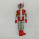 人形の背面全身。背中のファスナーと角付きヘルメット