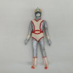 銀と白赤の衣装とヘルメットを着けた人形の全身を正面から写した写真