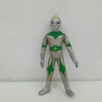 銀と緑のスーツを着たヒーロー人形の全身正面