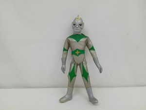 銀と緑のスーツを着たヒーロー人形の全身正面