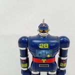 本体の上半身のアップ。頭部、胸の水色のパネル、赤いベルトの「T」マークが写っています。