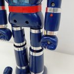 胴体と腕のアップ。赤いベルト、胸の丸い穴、握り拳が写っています。