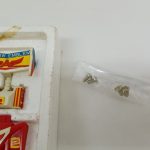 内箱の一部のアップ。白と黄色のウイング部品と、透明袋に入った銀色のネジ。