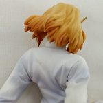 頭部と肩を後ろから近づけて写したもの。金色の髪と白い上着