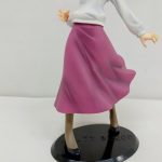 下半身を後ろから写したもの。広がった赤紫のスカートと黒い台座