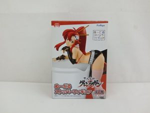 外箱の正面。赤い髪の女性キャラクターの写真と「ぬーどるストッパーフィギュア 全1種」「FuRyu」の印字。