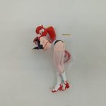 透明な袋に入った本体を斜め上から。うつ伏せの姿勢で、長い赤い髪が伸びています。