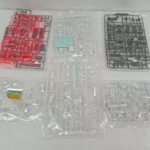 袋に入ったランナー（部品の枝）を並べたもの。赤・灰色・透明の部品