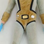 腰まわりの拡大。ベルトのバックルと青い手