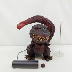 ゴジラのフィギュアを正面から写した写真。横に電源ユニットと支柱スタンド