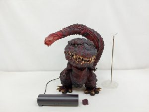 ゴジラのフィギュアを正面から写した写真。横に電源ユニットと支柱スタンド