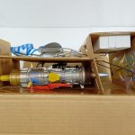 段ボールの仕切りに収まったエンジン部分と小さな部品