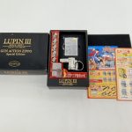 外箱と中箱、ライターと金属パーツ、ルパン三世のチラシ2枚を並べた様子