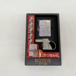 中箱の窓越しに見たライターとガンアクション用の金属パーツ。『LUPIN the 3rd』の台紙