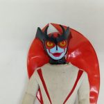 マスクを付けた頭部と赤い翼のアップ
