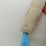 右腕の袖口と水色の手のアップ
