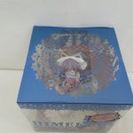 箱の上面。レース模様の窓から座ったフィギュアが見える