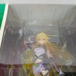 窓越しのフィギュアの拡大。金色の髪と白い衣装