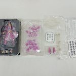 トレーに収まったフィギュア本体と、手首パーツ、紫のエフェクトパーツ、台座、吹き出しパーツ、説明書を並べた様子