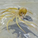 ブリスター越しのフィギュア上半身。金色の長い髪と黒い衣装