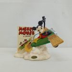 緑の飛行機に乗ったミッキーマウスのフィギュアと『MICKEY MOUSE in PLANE CRAZY』の看板