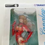 窓越しのフィギュアの上半身。Creators LaboとYAMATOのロゴ