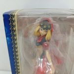 窓越しのフィギュアの上半身の拡大。赤いずきんと金色の髪